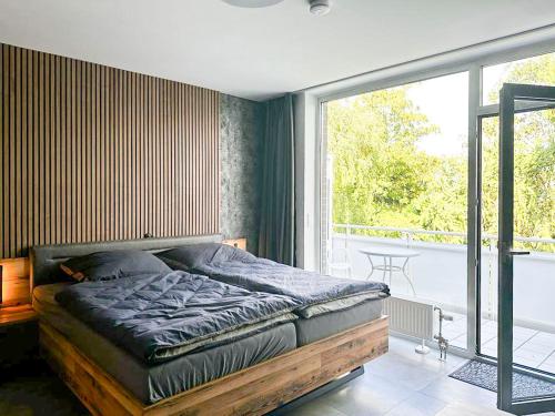 een slaapkamer met een bed en een groot raam bij Apartment Düsseldorf-Lohausen in Düsseldorf