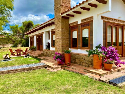 a house with flowers on the front yard at Casa de las Flores- Chalet Privado in Villa de Leyva