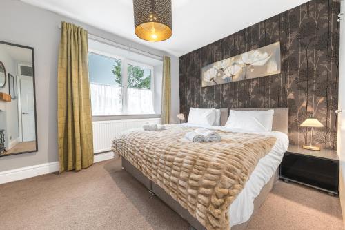 a bedroom with a large bed and a window at Sunny Brae, Windermere Cottage in Windermere