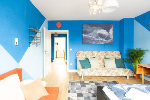 un soggiorno con pareti blu e divano di - Sea Apartment Duisburg Center & Parking spaces & Kingsize Bett - Central Station Hbf - a Duisburg
