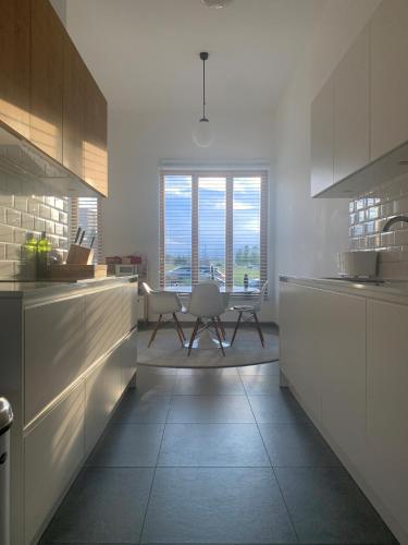 a kitchen with white cabinets and a table and a window at Luxury apartment, private terrace & FREE PARKING in Antwerp