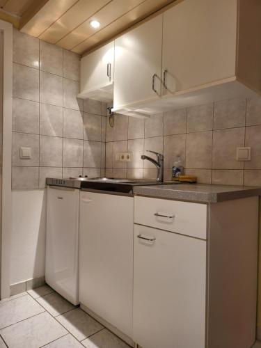 a kitchen with white cabinets and a sink at Ferienwohnung Zangl am Seggauberg - Südsteiermark in Leibnitz