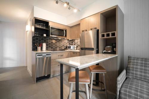 a kitchen with a table and a refrigerator at Lake Louise Inn in Lake Louise