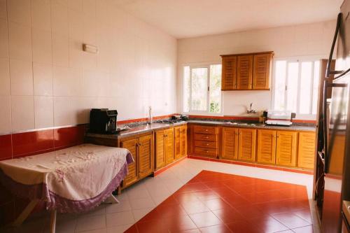 a kitchen with wooden cabinets and a bed in it at Villa Vue sur la Méditerranée in Cabo Negro