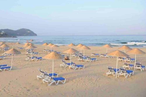 a bunch of chairs and umbrellas on a beach at Villa Vue sur la Méditerranée in Cabo Negro