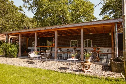 a house with a patio with chairs and tables at Boutiquehotel & Tiny houses PLEK17 in Milsbeek