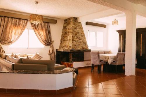 a living room with a couch and a fireplace at Villa Vue sur la Méditerranée in Cabo Negro