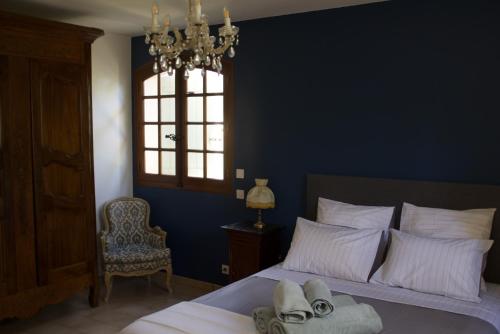 a bedroom with a bed with a chandelier and a window at Villa Grand Cèdre in Marseille