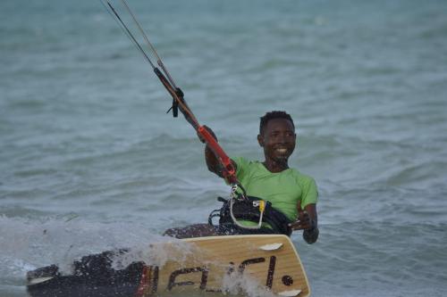 a man on a board in the water at Mem Luxury Apartments and Hotel in Paje
