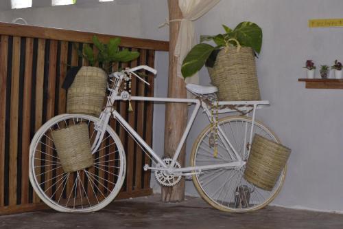 a white bike with baskets on the side of a room at Mem Luxury Apartments and Hotel in Paje