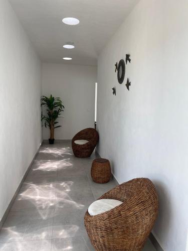 a hallway with two wicker chairs in a room at Villas Miland - San Benito Beach in San Benito