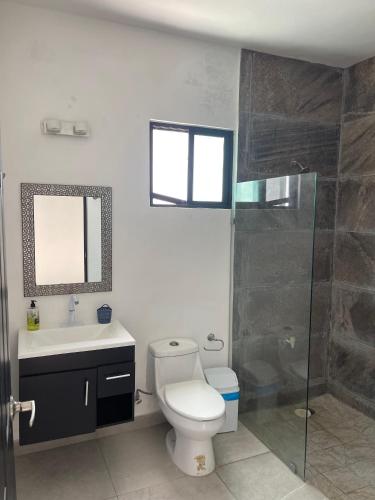 a bathroom with a toilet and a sink and a shower at Villas Miland - San Benito Beach in San Benito
