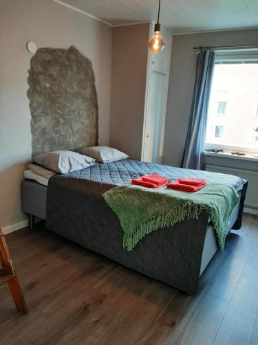 ein Schlafzimmer mit einem Bett mit zwei roten Gerichten darauf in der Unterkunft Kaski, three-room condo in a prime location, free parking in Tampere
