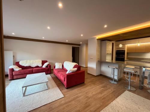 sala de estar con 2 sofás rojos y cocina en Newly renovated 7-9pers Luxury Chalet in Meribel Centre 85m2 3BR 3BA with stunning Mountain View en Méribel