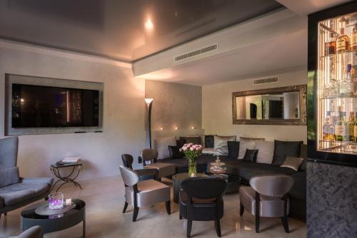 a living room with a couch and tables and chairs at Hostellerie Les Gorges De Pennafort in Callas