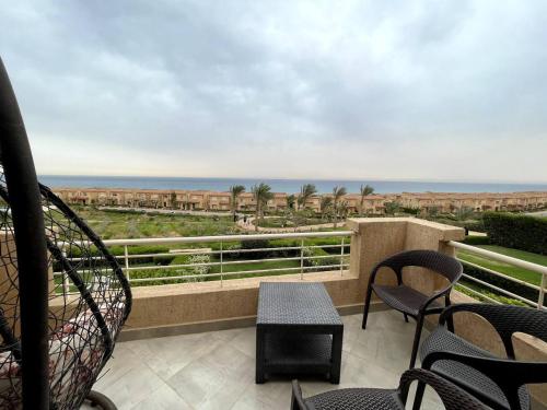 a balcony with chairs and a view of the ocean at Spacious Penthouse Chalet at Telal Sokhna in Ain Sokhna
