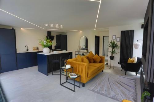 a living room with a yellow couch and a kitchen at 99 at Lynian Farm in Blackpool