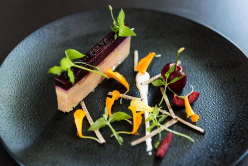 a piece of cake on a black plate with vegetables at Hostellerie Les Gorges De Pennafort in Callas