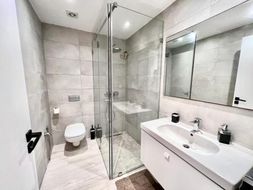 uma casa de banho com um lavatório, um chuveiro e um WC. em "Luxe Residence" Marsa avec Parking em Tunes