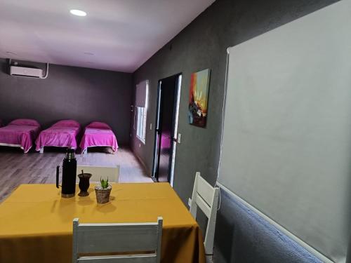 una sala da pranzo con tavolo e cuscini rosa di Residencia Dos Soles 2.0 a Resistencia