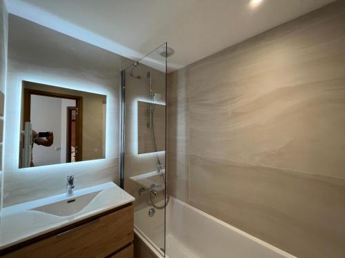 y baño con lavabo y espejo. en Newly renovated 7-9pers Luxury Chalet in Meribel Centre 85m2 3BR 3BA with stunning Mountain View, en Méribel