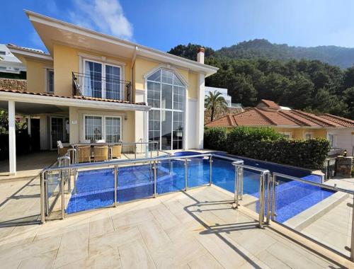 a swimming pool in front of a house at Alanya Family Paradise Sea View in Alanya