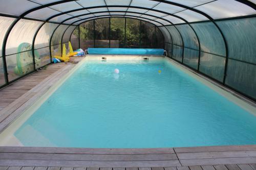 an indoor swimming pool with a greenhouse at Entre mare et chêne in Frasnes-lez-Anvaing
