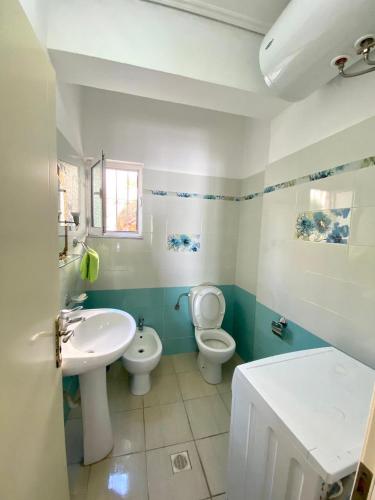 ein Badezimmer mit einem Waschbecken, einem WC und einem Waschbecken in der Unterkunft Panoramic Apartment Amelia in Sarandë