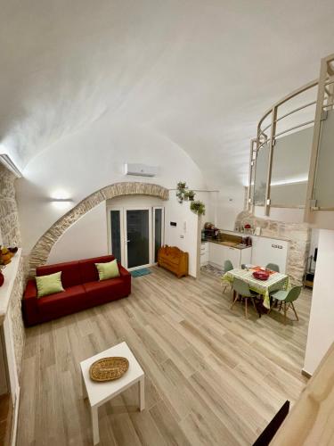 a living room with a red couch and a table at Casina dei Fiori in Molfetta