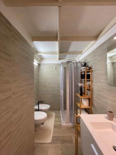 a bathroom with two sinks and a toilet and a shower at Casina dei Fiori in Molfetta