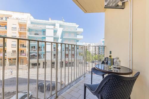 a balcony with a table and chairs and a building at Beachside Bliss in Armação de Pêra