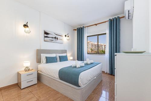 a bedroom with a bed and a window at Beachside Bliss in Armação de Pêra