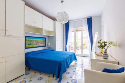 Un dormitorio azul con una cama y una silla. en seaview apartment short lets, en Sant'Agnello