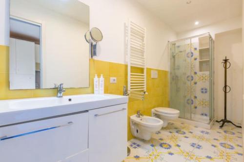 Un baño con lavabo, inodoro y ducha. en seaview apartment short lets, en Sant'Agnello