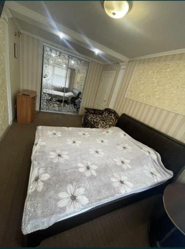 Un dormitorio con una cama con flores. en Богоявленский проспект, 43 Апартаменты en Mykolaiv