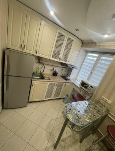 Il comprend une petite cuisine équipée d'une table et d'un réfrigérateur. dans l'établissement Богоявленский проспект, 43 Апартаменты, à Mykolaïv