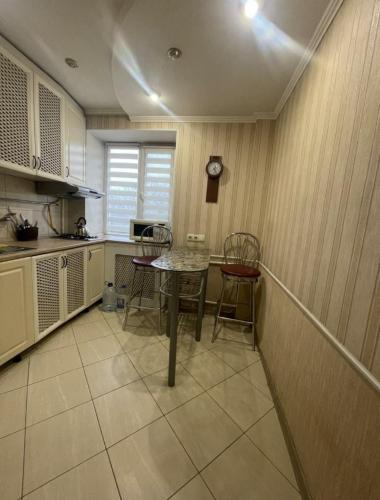 - une cuisine avec une table et des chaises dans la chambre dans l'établissement Богоявленский проспект, 43 Апартаменты, à Mykolaïv