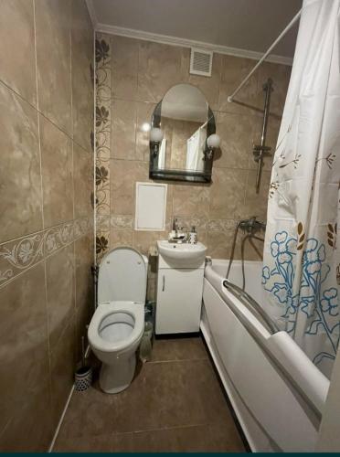 La salle de bains est pourvue de toilettes, d'un lavabo et d'une baignoire. dans l'établissement Богоявленский проспект, 43 Апартаменты, à Mykolaïv