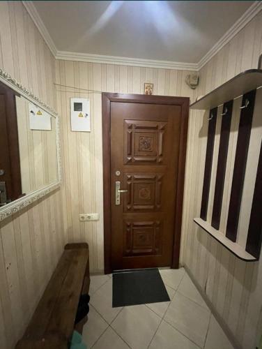 Cette chambre dispose d'une porte en bois et d'un banc. dans l'établissement Богоявленский проспект, 43 Апартаменты, à Mykolaïv