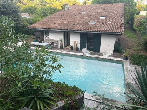 een groot zwembad voor een huis bij Villa Athena Cap-Ferret chez l habitant in Lège-Cap-Ferret