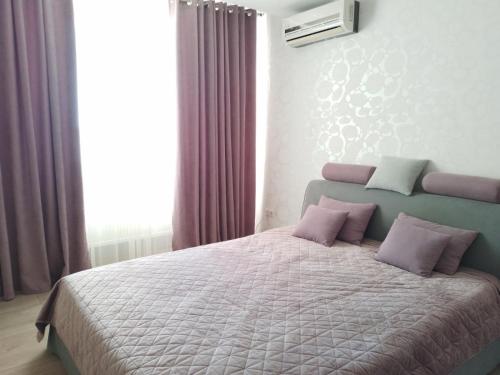 a bedroom with a large bed with purple pillows at Apartament Panoramic ALBA IULIA in Chişinău
