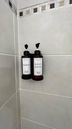 Deux bouteilles de savon assises sur une étagère dans une salle de bains dans l'établissement L'Echapée SENSée : Duplex Centre 500m Cathédrale, à Sens