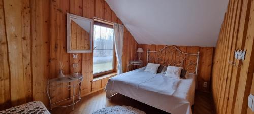 een slaapkamer met een bed in een houten kamer bij Jõesuu Puhkemaja OÜ in Verevi