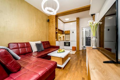 a living room with a red couch and a table at Apartment Urban Garden in Belgrade