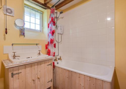 a bathroom with a tub and a sink at 1 New Thatched Cottage in Edingthorpe