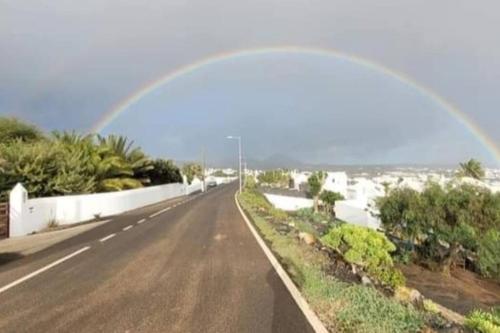 a rainbow over a road with trees and bushes at Casa Kira, Macher in Mácher