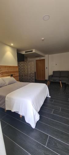 a hotel room with a large bed and a couch at Lumen Place APARTAMENTOS in Mondoñedo