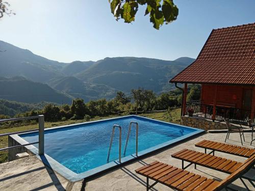 einen Pool mit zwei Stühlen und ein Haus in der Unterkunft Dobar pogled in Bajina Bašta