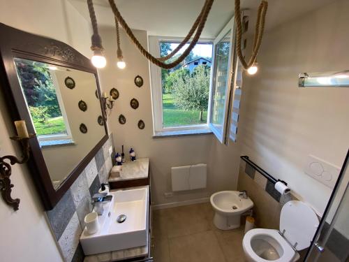 La salle de bains est pourvue d'un lavabo, de toilettes et d'un miroir. dans l'établissement Cascina Vica Biella, à Andorno Micca