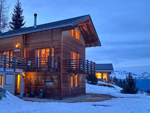 une cabane en rondins dans la neige au crépuscule dans l'établissement La Pourvoirie - 4 Vallées - Thyon-Les Collons, 10 personnes, pistes de ski à 200m, magnifique vue, à Hérémence